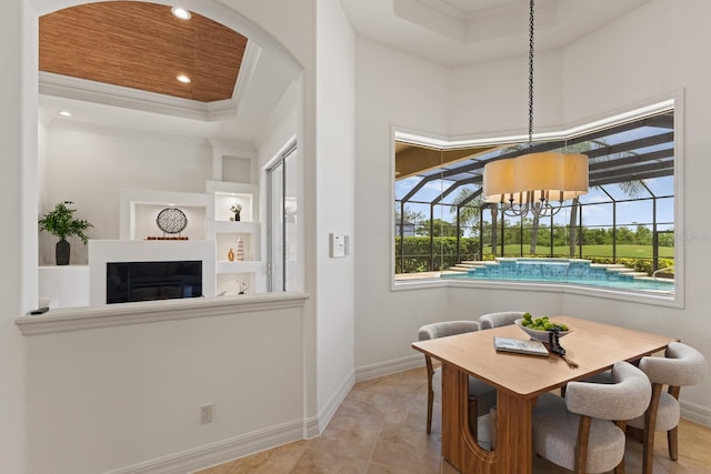 7144 Ashland Gln, Lakewood Ranch, FL 34202 - dining area featuring crown molding, a glass covered fireplace, a raised ceiling, arched walkways, and recessed lighting