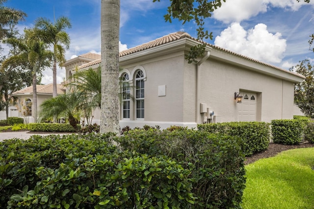 7144 Ashland Gln, Lakewood Ranch, FL 34202 - view of side of property with a tile roof and stucco siding