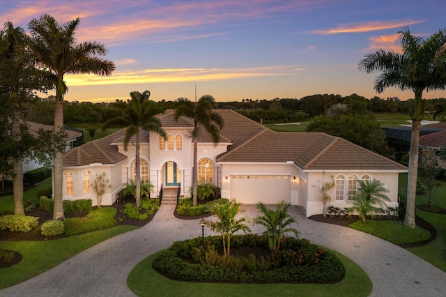 7144 Ashland Gln, Lakewood Ranch, FL 34202 - view of front of house with curved driveway, an attached garage, stucco siding, and a tile roof