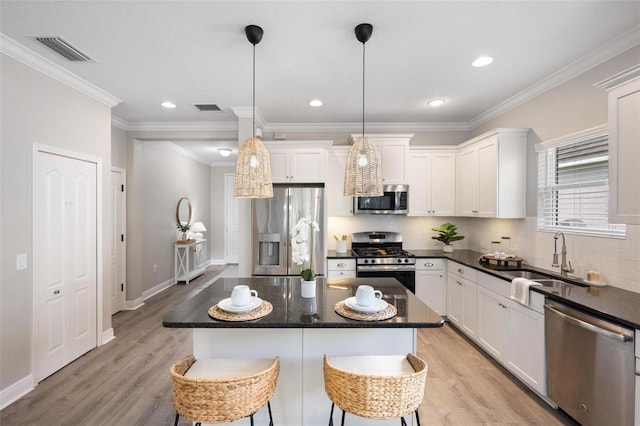 12261 Stuart Dr, Venice, FL 34293 - kitchen featuring appliances with stainless steel finishes, light wood-style flooring, decorative backsplash, white cabinetry, and crown molding