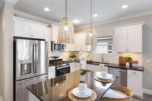 12261 Stuart Dr, Venice, FL 34293 - kitchen with stainless steel appliances, white cabinetry, pendant lighting, a center island, and ornamental molding