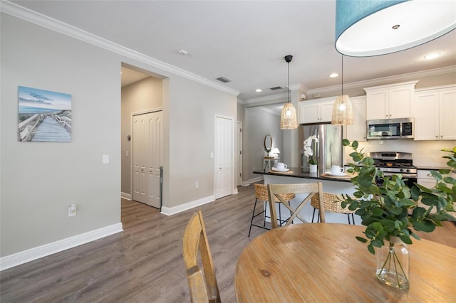12261 Stuart Dr, Venice, FL 34293 - dining room with dark wood finished floors, crown molding, and recessed lighting
