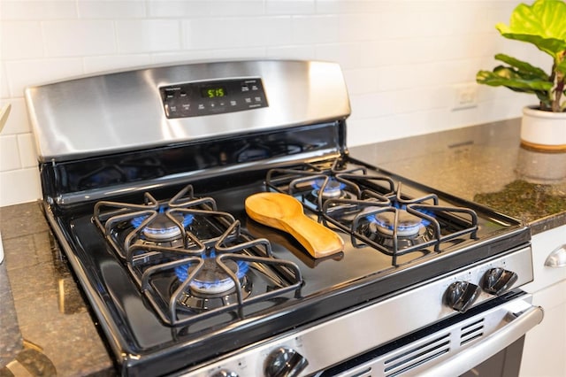 12261 Stuart Dr, Venice, FL 34293 - kitchen view of stainless steel range with gas stovetop, dark countertops, and backsplash