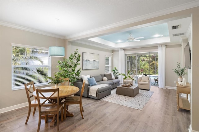 12261 Stuart Dr, Venice, FL 34293 - dining area featuring a tray ceiling, plenty of natural light, light wood finished floors, and crown molding