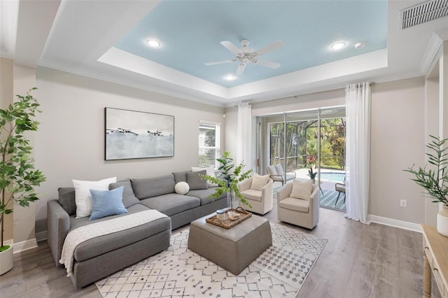12261 Stuart Dr, Venice, FL 34293 - living room featuring a tray ceiling, a ceiling fan, light wood finished floors, and recessed lighting