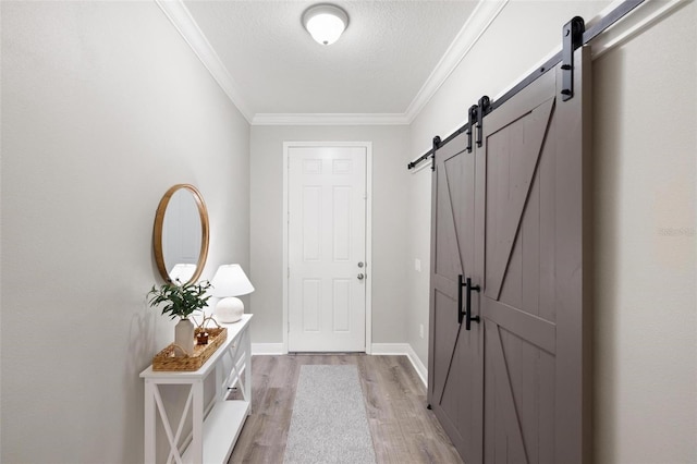 12261 Stuart Dr, Venice, FL 34293 - entryway with a barn door, light wood-style flooring, crown molding, and a textured ceiling