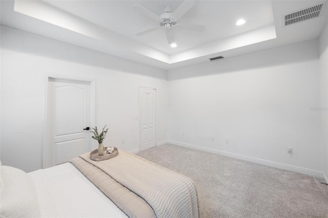 12261 Stuart Dr, Venice, FL 34293 - bedroom featuring light colored carpet, recessed lighting, a tray ceiling, and a ceiling fan