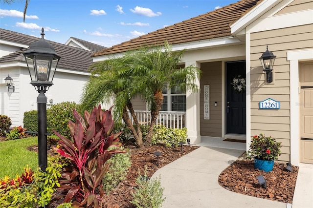 12261 Stuart Dr, Venice, FL 34293 - doorway to property with a tiled roof and covered porch