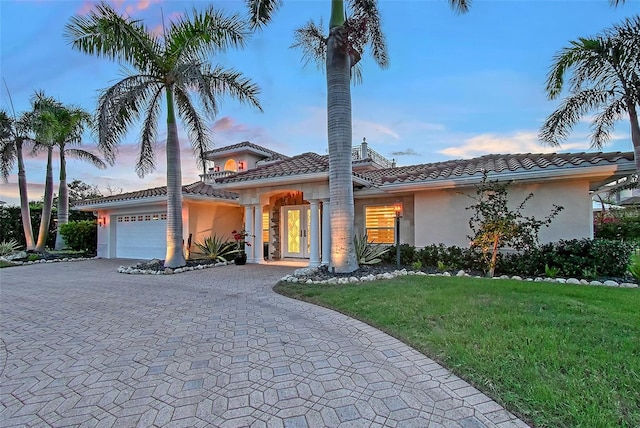 571 Birdie Ln, Longboat Key, FL 34228 - mediterranean / spanish-style home with stucco siding, a garage, decorative driveway, a yard, and a tile roof