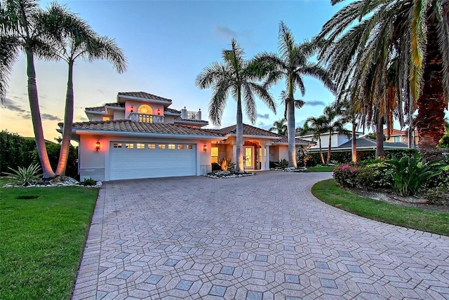 571 Birdie Ln, Longboat Key, FL 34228 - mediterranean / spanish-style home with stucco siding, curved driveway, an attached garage, and a tile roof