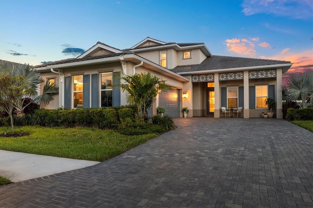 8209 Redonda Loop, Lakewood Ranch, FL 34202 - view of front facade featuring stucco siding, decorative driveway, a garage, and a front yard