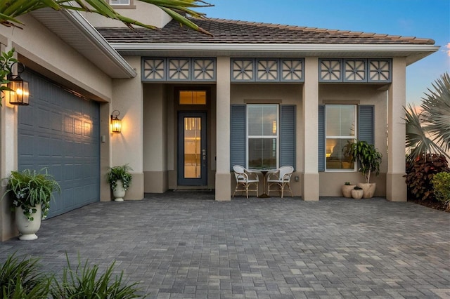 8209 Redonda Loop, Lakewood Ranch, FL 34202 - view of exterior entry featuring stucco siding, decorative driveway, and an attached garage