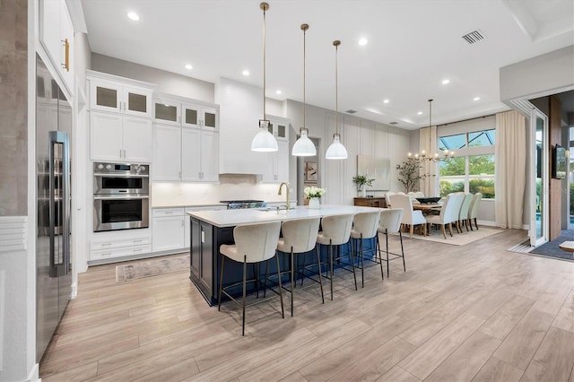 8209 Redonda Loop, Lakewood Ranch, FL 34202 - kitchen featuring appliances with stainless steel finishes, light wood-style flooring, light countertops, a large island, and recessed lighting