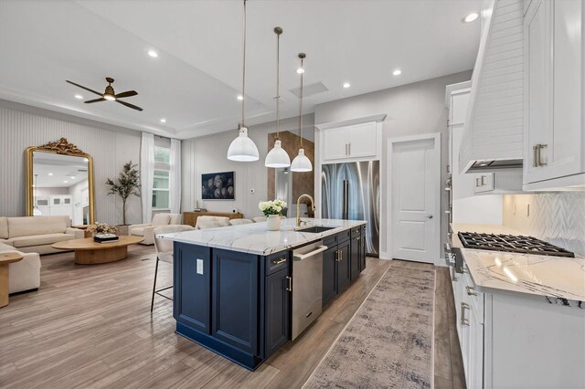 8209 Redonda Loop, Lakewood Ranch, FL 34202 - kitchen with open floor plan, appliances with stainless steel finishes, light wood finished floors, white cabinets, and recessed lighting