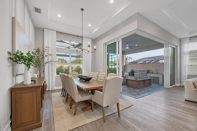 8209 Redonda Loop, Lakewood Ranch, FL 34202 - dining space featuring a raised ceiling, light wood-style flooring, a chandelier, and recessed lighting