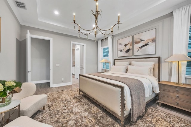8209 Redonda Loop, Lakewood Ranch, FL 34202 - bedroom with a raised ceiling, a chandelier, wood finished floors, recessed lighting, and ensuite bathroom