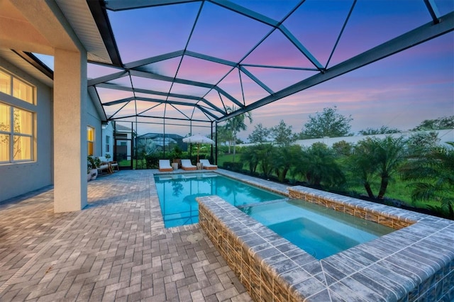 8209 Redonda Loop, Lakewood Ranch, FL 34202 - pool at dusk with a patio area, a pool with connected hot tub, and a lanai