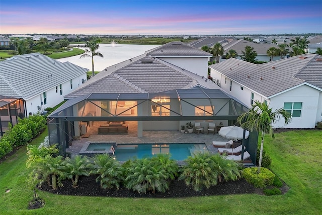 8209 Redonda Loop, Lakewood Ranch, FL 34202 - back of house at dusk with a patio area, glass enclosure, a pool with connected hot tub, and a residential view