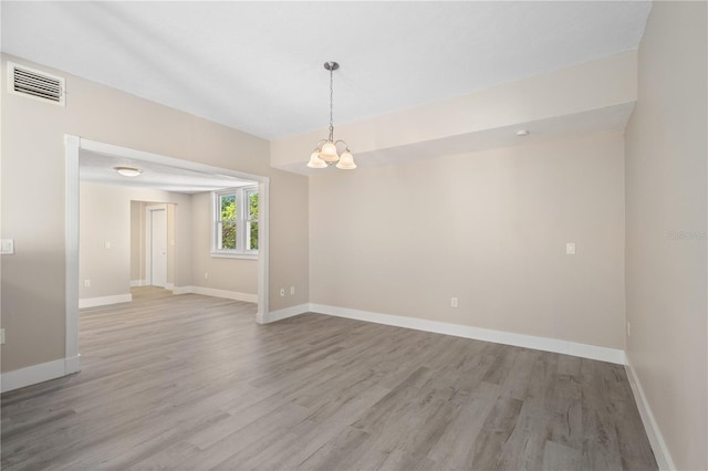 719 22nd St W, Bradenton, FL 34205 - spare room featuring light wood-style flooring and a chandelier