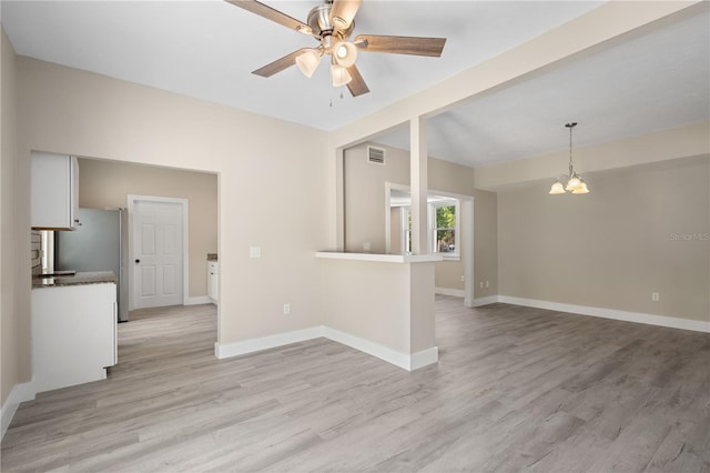 719 22nd St W, Bradenton, FL 34205 - unfurnished living room with light wood-style flooring, ceiling fan, and a chandelier