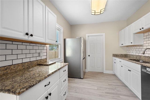 719 22nd St W, Bradenton, FL 34205 - kitchen featuring freestanding refrigerator, dishwasher, stone countertops, decorative backsplash, and light wood-style floors