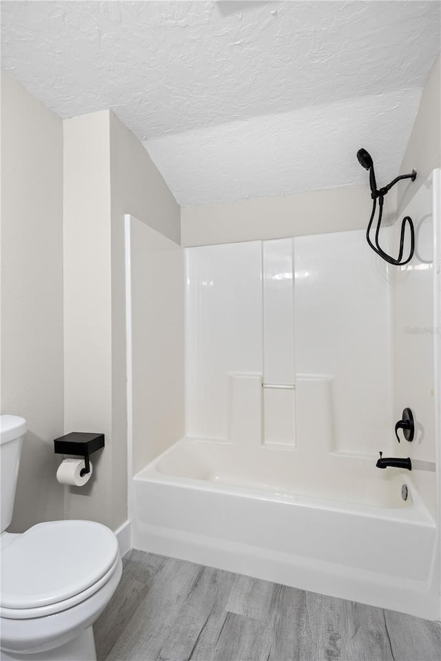 719 22nd St W, Bradenton, FL 34205 - full bath with wood finished floors, shower / bathtub combination, and a textured ceiling