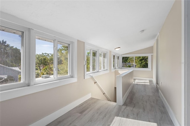719 22nd St W, Bradenton, FL 34205 - hall with wood finished floors, an upstairs landing, and vaulted ceiling