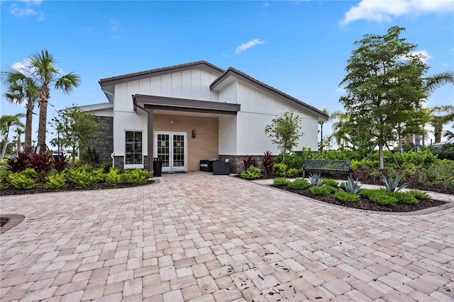 17209 Barnwood Pl, Bradenton, FL 34211 - rear view of property featuring french doors, stone siding, and board and batten siding