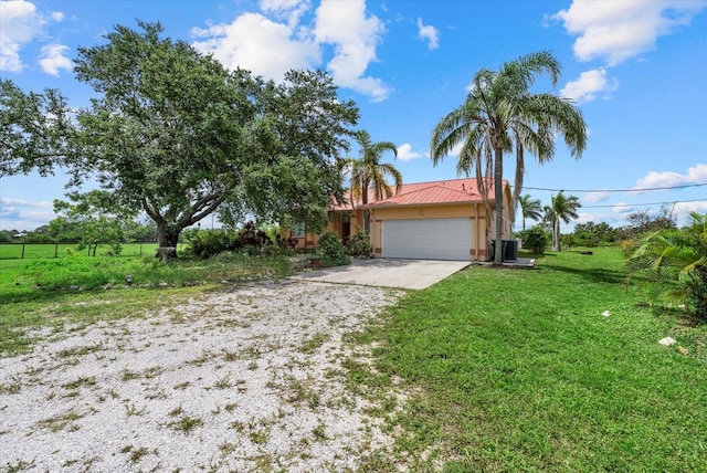 6805 225th St E, Bradenton, FL 34211 - obstructed view of property with driveway, an attached garage, stucco siding, a front lawn, and a metal roof
