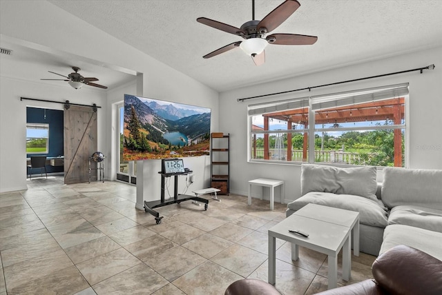 6805 225th St E, Bradenton, FL 34211 - living room featuring ceiling fan, vaulted ceiling, a barn door, and a textured ceiling