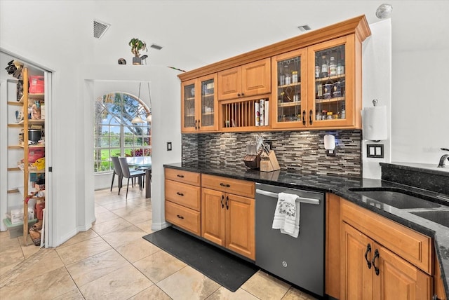 6805 225th St E, Bradenton, FL 34211 - kitchen featuring stainless steel dishwasher, backsplash, dark stone counters, brown cabinetry, and glass insert cabinets