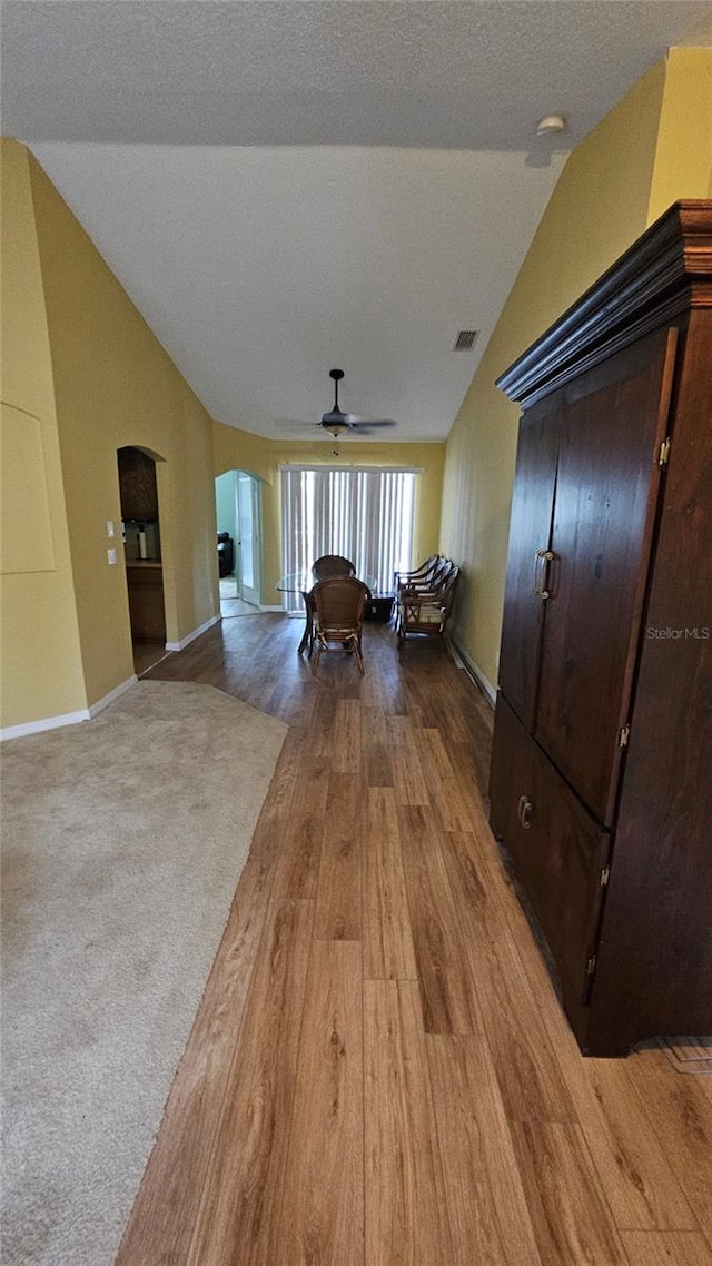 17215 Berwin Ave, Port Charlotte, FL 33948 - corridor with vaulted ceiling, arched walkways, wood finished floors, and a textured ceiling