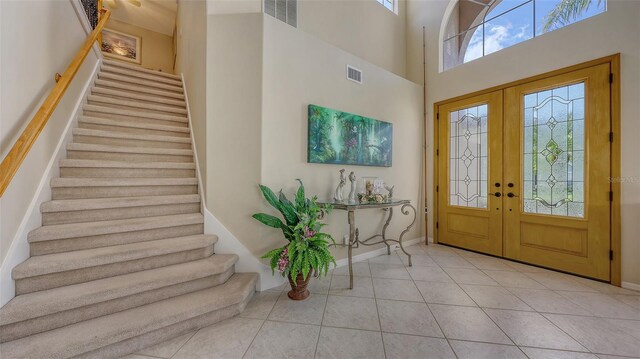 7915 Kavanagh Ct, Sarasota, FL 34240 - entryway featuring stairway, plenty of natural light, french doors, tile patterned floors, and a towering ceiling