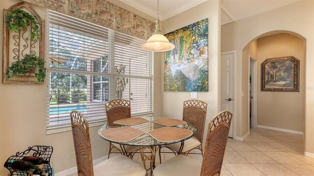 7915 Kavanagh Ct, Sarasota, FL 34240 - dining area featuring ornamental molding, arched walkways, and light tile patterned flooring