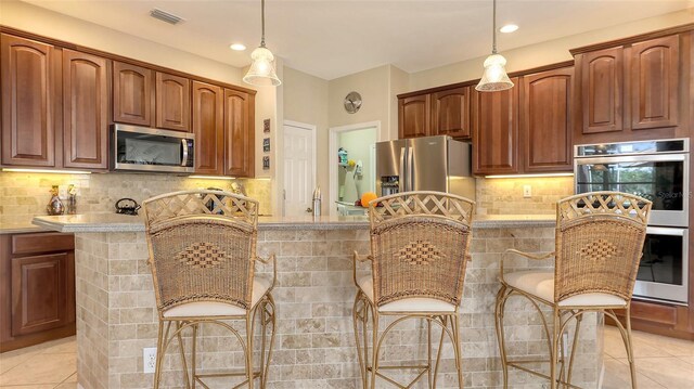 7915 Kavanagh Ct, Sarasota, FL 34240 - kitchen featuring stainless steel appliances, light tile patterned floors, decorative light fixtures, and recessed lighting