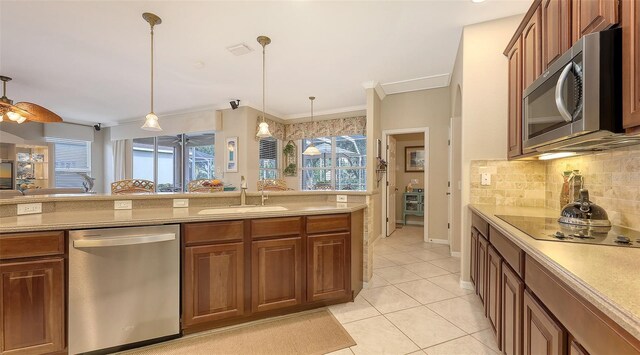7915 Kavanagh Ct, Sarasota, FL 34240 - kitchen with appliances with stainless steel finishes, tasteful backsplash, decorative light fixtures, light tile patterned floors, and light countertops