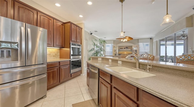 7915 Kavanagh Ct, Sarasota, FL 34240 - kitchen featuring appliances with stainless steel finishes, ceiling fan, plenty of natural light, hanging light fixtures, and crown molding