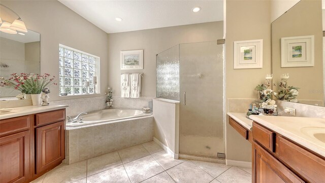 7915 Kavanagh Ct, Sarasota, FL 34240 - bathroom featuring two vanities, tile patterned floors, a stall shower, a garden tub, and recessed lighting