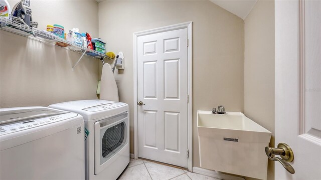 7915 Kavanagh Ct, Sarasota, FL 34240 - washroom with washing machine and clothes dryer and light tile patterned floors