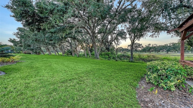 7915 Kavanagh Ct, Sarasota, FL 34240 - yard at dusk featuring a lawn
