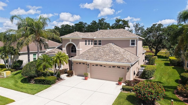 7915 Kavanagh Ct, Sarasota, FL 34240 - view of front facade with stucco siding, a garage, concrete driveway, and a front lawn