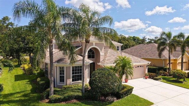 7915 Kavanagh Ct, Sarasota, FL 34240 - mediterranean / spanish-style house featuring an attached garage, driveway, stucco siding, and a front yard