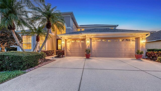 7915 Kavanagh Ct, Sarasota, FL 34240 - view of front of property with concrete driveway, a garage, stucco siding, and roof with shingles