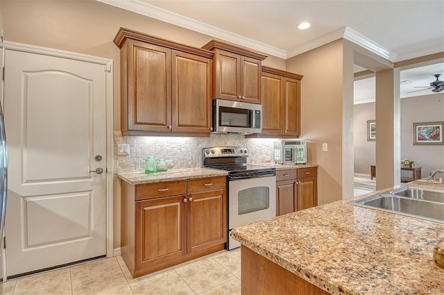 6214 45th Ln E, Bradenton, FL 34203 - kitchen with appliances with stainless steel finishes, decorative backsplash, brown cabinetry, crown molding, and recessed lighting