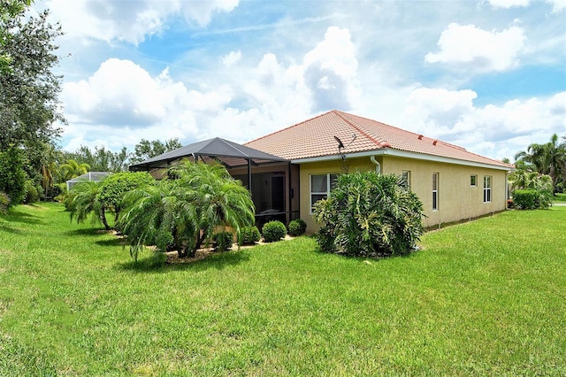 6214 45th Ln E, Bradenton, FL 34203 - back of property featuring a tile roof, a lawn, a lanai, and stucco siding