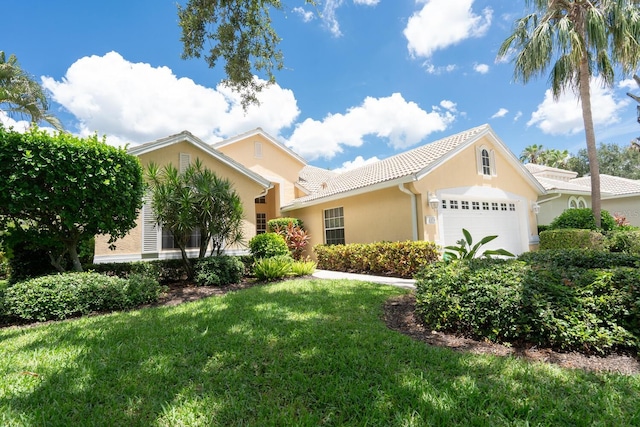 4374 Mirabella Cir, Bradenton, FL 34210 - view of front facade featuring an attached garage, stucco siding, a front lawn, and a tile roof