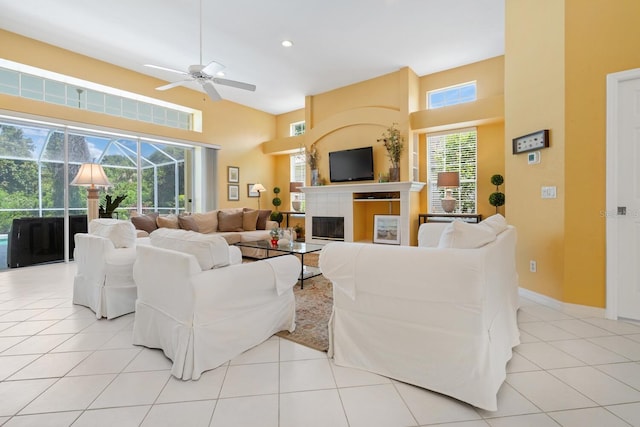 4374 Mirabella Cir, Bradenton, FL 34210 - living room featuring ceiling fan, light tile patterned flooring, a high ceiling, and a glass covered fireplace