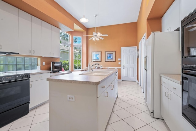 4374 Mirabella Cir, Bradenton, FL 34210 - kitchen featuring black appliances, light tile patterned flooring, light countertops, and a towering ceiling