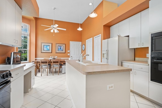 4374 Mirabella Cir, Bradenton, FL 34210 - kitchen featuring a towering ceiling, black appliances, light tile patterned floors, light countertops, and ceiling fan