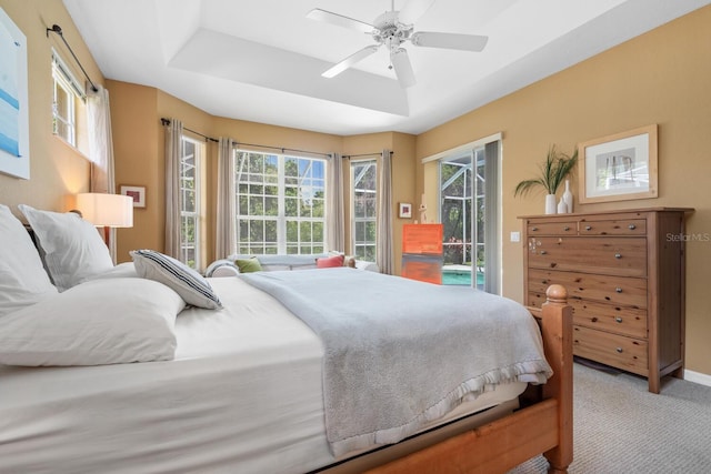 4374 Mirabella Cir, Bradenton, FL 34210 - carpeted bedroom featuring access to outside, multiple windows, a tray ceiling, and ceiling fan